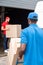 multiethnic delivery men in red and blue uniform with cardboard