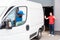 multiethnic delivery men in uniform parking white van