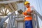 Multiethnic engineer working with clipboard in plant