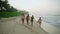 Multiethnic female surfers walking along the beach at sunrise. Multiracial surfer girls carrying surfboards walking on