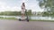 Multiethnic girl ride electric scooter along the river