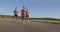 Multiethnic group of athletes running together on a panoramic countryside road. Diverse Team of joggers on morning
