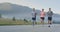 Multiethnic group of athletes running together on a panoramic countryside road. Diverse Team of joggers on morning