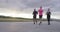 Multiethnic group of athletes running together on a panoramic countryside road. Diverse team of joggers on morning