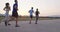 Multiethnic group of athletes running together on a panoramic countryside road. Diverse Team of joggers on morning