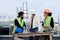 Multiethnic group of workers architect and two engineers have a conversation on the rooftop of building analyzing
