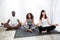 Multiethnic happy family relaxing together in lotus pose at home