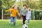 Multiethnic kids playing football near friends
