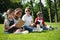 Multiethnic kids in sunglasses reading books in park