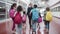 Multiethnic kids walking along corridor with female teacher