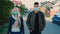 Multiethnic man and woman in medical masks walking down the street in housing estate