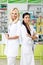 multiethnic pharmacists with digital tablet standing with crossed arms and smiling at camera