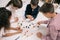 Multiethnic schoolkids studying with molecular model at chemistry lesson