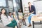 multiethnic smiling business coworkers looking at camera while having coffee break