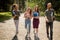 Multiethnic students walking on campus on sunny day.