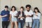 Multiethnic teens standing with smartphones, reading messages