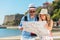 Multiethnic traveler couple using generic local map together on sunny day.