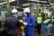 Multiethnic worker, supervisor wearing mask in manufacturing factory on business day