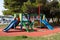 Multifunctional outdoor public playground equipment with blue plastic slide next to climbing net and wall connected with safety