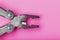 Multifunctional tool close-up on a pink background. The concept of a pocket tool with free space.