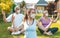 Multigenerational group of people making yoga exercises outdoors wearing medical protective masks