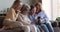 Multigenerational women family sit on couch having fun using smartphone