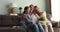 Multigenerational women family sit on sofa with postcard and flowers