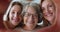 Multigenerational women looking through joined fingers showing heart shape, closeup