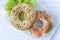 Multigrain bagel with cream cheese, salmon slices, dill and salad, top view