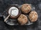 Multigrain multiseed fitness buns and greek yogurt on rustic wooden chopping board on dark background, top view