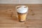 Multilayer coffee or cappuccino in a glass cup on wooden table