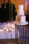 Multilevel wedding cake on the background of candles