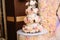 Multilevel wedding cake decorated with flowers stands on a table. Concept of eating, sweets and desserts at a party.