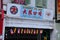 Multilingual shop sign in mandarin Chinese Malay and Arabic Jawi Malay with flags Kuching Sarawak Malaysia
