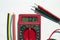 Multimeter with text on display 12 V and heat shrink insulation on white background