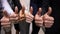 Multinational businesspeople standing in row showing thumbs up gesture closeup