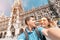 Multinational couple in love hugs and takes a selfie photo on the background of The city hall tower in Munich. Honeymoon