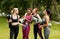 Multinational girls with yoga mats talking and laughing after outdoor yoga class