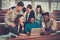 Multinational group of cheerful students taking an active part in a lesson while sitting in a lecture Hall.