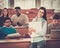 Multinational group of cheerful students taking an active part in a lesson while sitting in a lecture Hall.