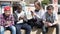 Multinational teenagers play in smartphones in schoolyard