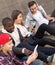 Multinational teenagers play in smartphones in schoolyard