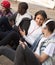 multinational teenagers play in smartphones in schoolyard