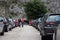 Multiple Alfa Romeos lined up at a car park in a row. People walking among them admiring, part of a Croatian enthusiast event