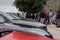 Multiple Alfa Romeos parked in a row, people grouped up talking, enjoying their day as a part of a Croatian Alfa Romeo enthusiast