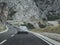 Multiple Alfa Romeos in perfect line driving together as a part of an enthusiast event in Croatia. Silver 159 in focus, driving on