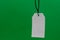 Multiple blank white tag price hanging on green background