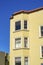 Multiple buildings in the city with beige stucco and white accent paint on windows with flat roof and background