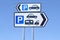 Multiple car parking and caravan motorhome signs against blue sky