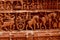 Multiple characters of artificial sculptures on a red wall of a temple